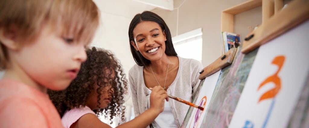 adulto con niños pintando